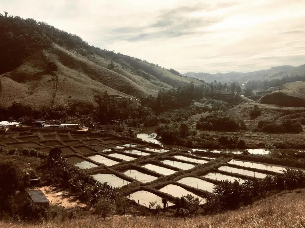 Vista dos tanques da Piscicultura Onibene entre as montanhas